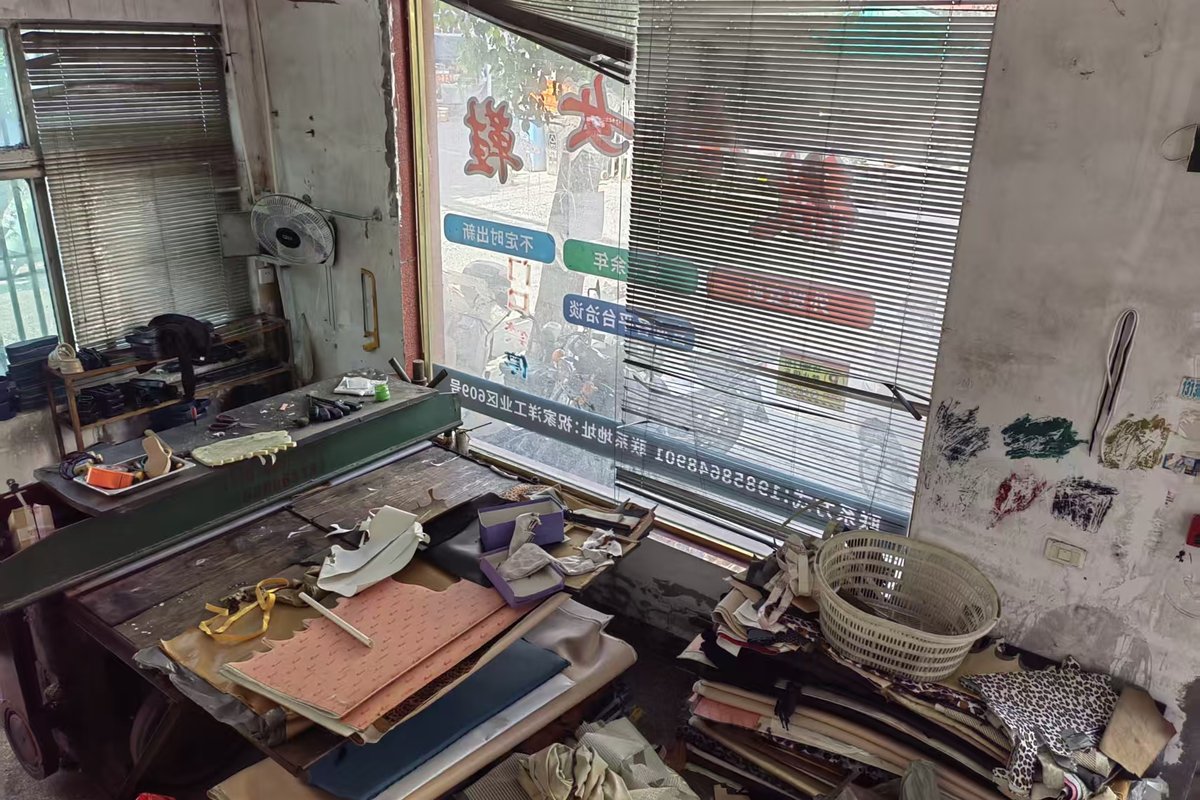 A shoemaker's workbench with pattern pieces, hand tools and a partly assembled women's shoe